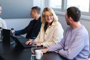 DATAGROUP Mitarbeitende unterhalten sich am Tisch in einem Meeting.