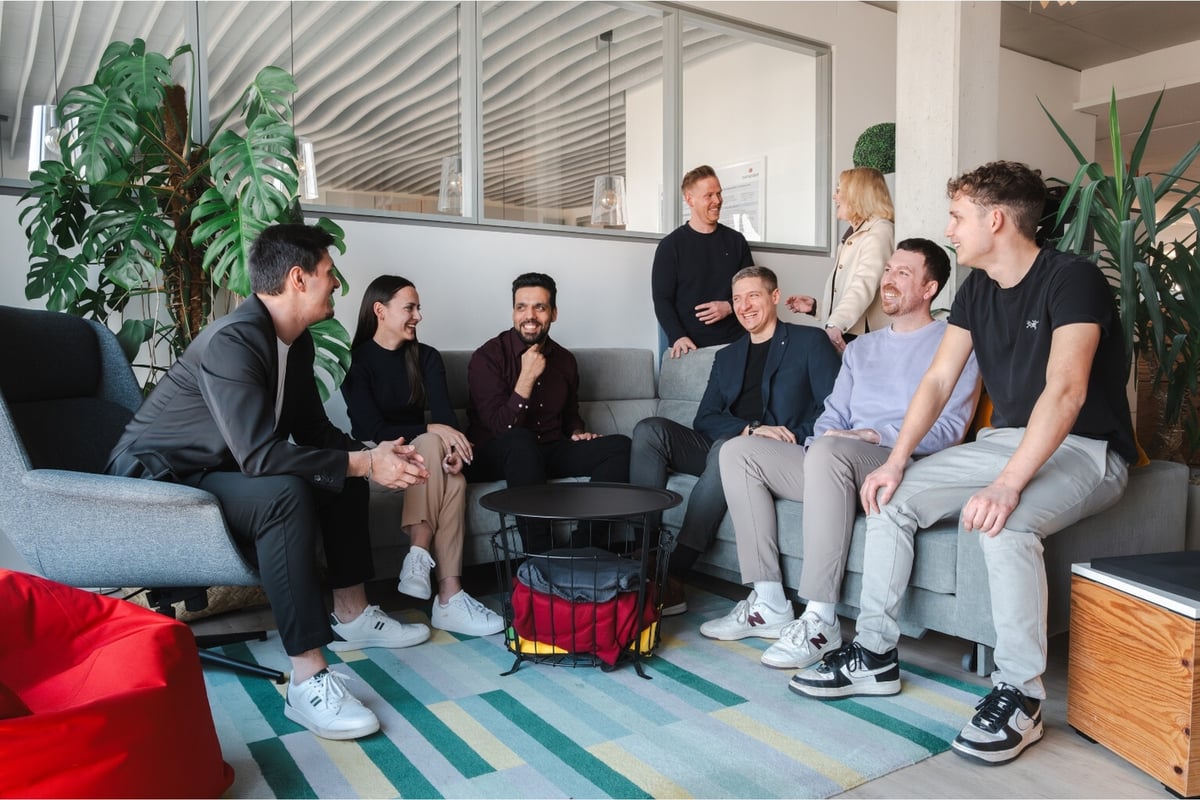 DATAGROUP Mitarbeitende sitzen zusammen und lachen gemeinsam.