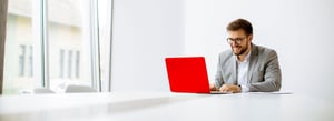 Mann_Laptop_rot_sitzend