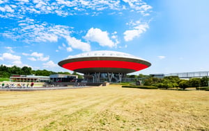 A cityscape of Eindhoven featuring modern architecture and a red graphic design element in the foreground.