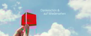 Eine Hand hält das rote DATAGROUP-Signet vor blauem Himmel mit Wolken und dem Schriftzug „Dankeschön & auf Wiedersehen“.