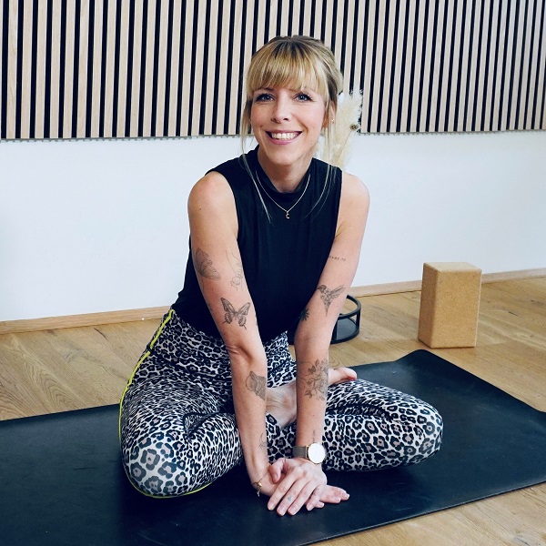 Julia Mantik – Marketingreferentin bei DATAGROUP Hamburg und Yoga-Trainerin – sitzt lächelnd auf der Matte – Symbol für Gelassenheit, Bewegung und innere Balance im Rahmen der DATAGROUP Gesundheitswoche.
