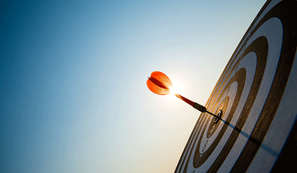 Eine Zielscheibe mit einem Pfeil im Zentrum, von der Sonne angestrahlt. Symbolisiert die erfolgreiche Einführung und zielgerichtete Nutzung von Microsoft 365.