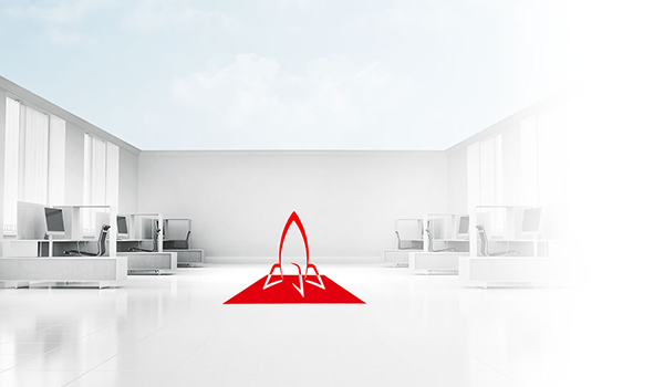 Modernes, leeres Großraumbüro in Weiß mit Computerarbeitsplätzen, in der Mitte ein rotes Raketen-Symbol.