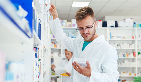 Apotheker räumt Regale in der Apotheke ein