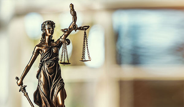 Justitia Figur steht auf einem Tisch