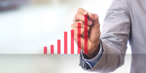 Mann zeichnet ansteigende Balken mit rotem Stift